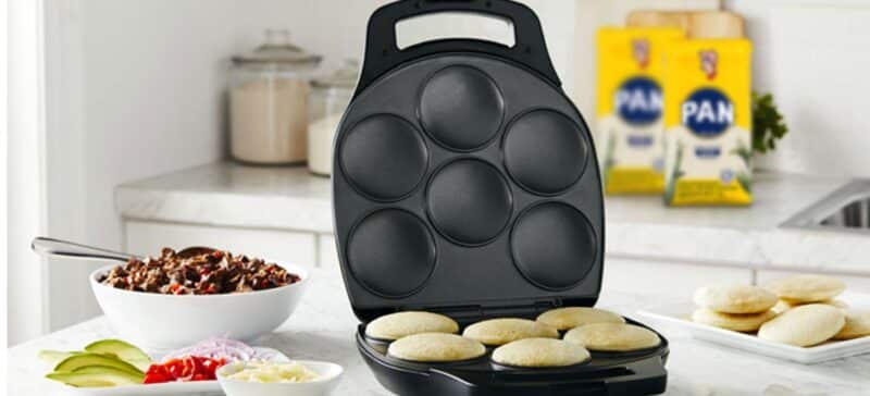 Tosti arepa sobre mesa con ingredientes para rellenar las arepas