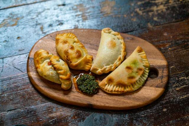 Empanadas argentinas sobre una tabla de madera/ Daniel Torobekov