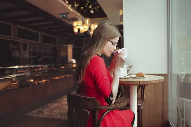 Chica sentada tomando Café en cafetería /Andrea Piacquadio